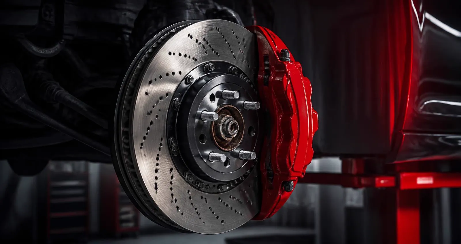Mechanik pri diagnostike brzdového systému drží demontovaný brzdový kotúč nad zdvihákom